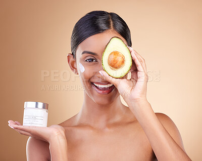 Buy stock photo Skincare, avocado and cream with portrait of Indian woman in studio for product, cosmetics and beauty. Self care, glow and natural with model and lotion for facial, spa and youth on brown background