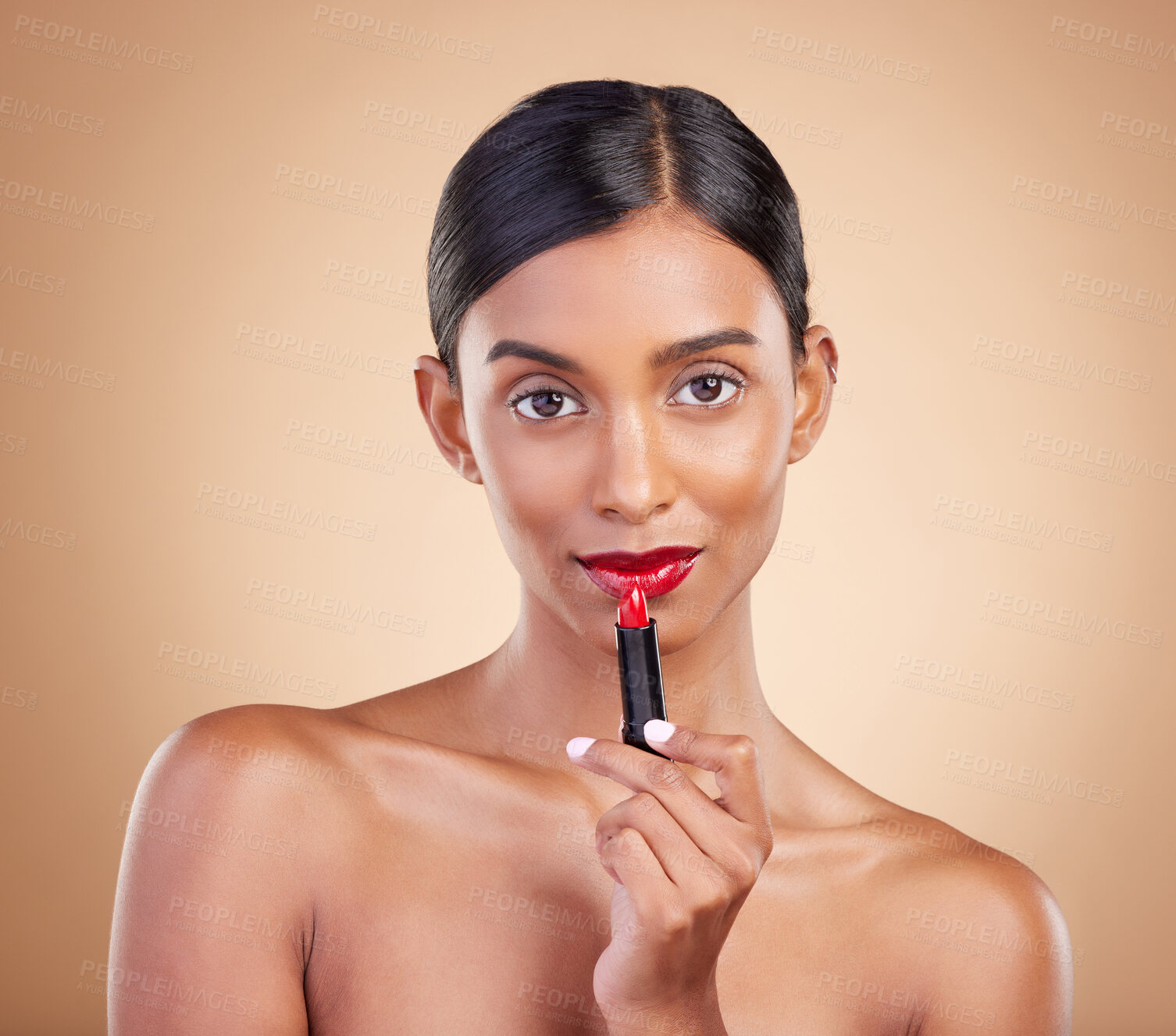 Buy stock photo Indian woman, lipstick product and studio portrait for beauty, wellness or skincare by brown background. Asian model, girl and red makeup on lips with natural glow, self care or cosmetology for youth