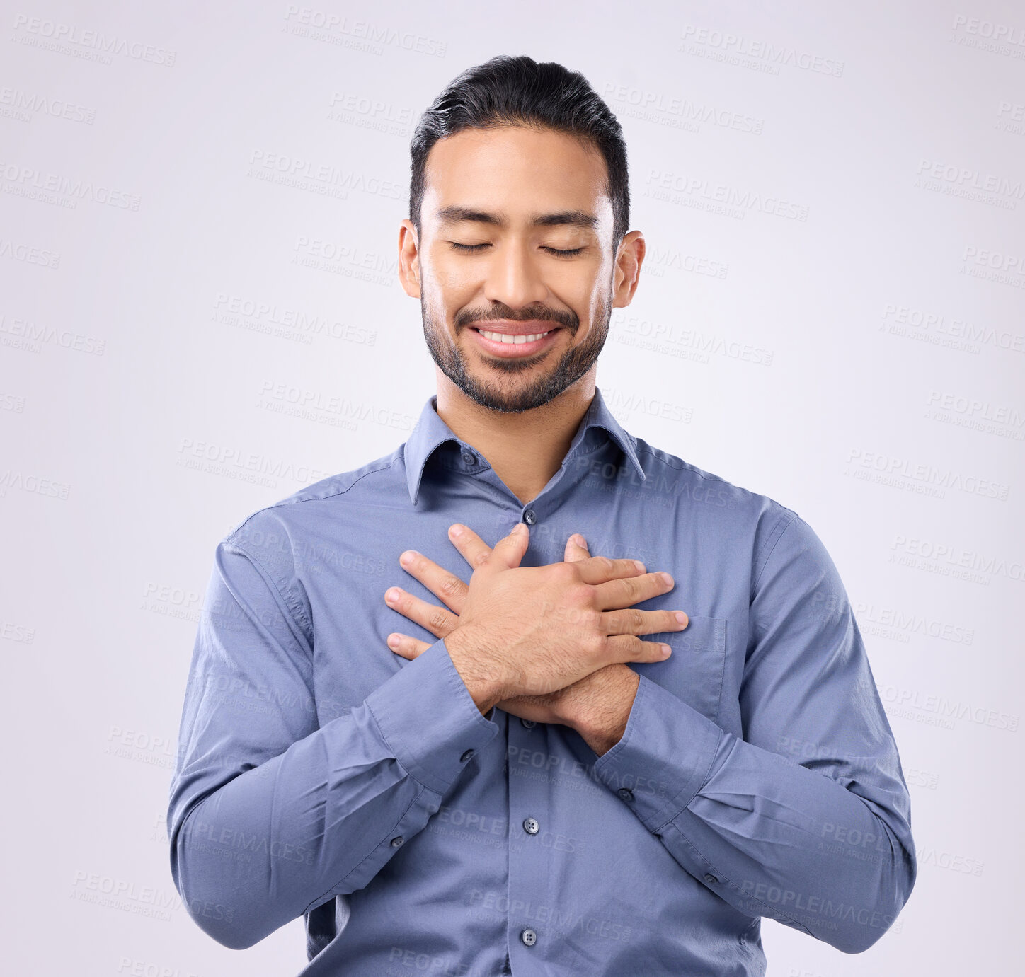 Buy stock photo Pray, hands on chest and happy man in studio with self love, hope and love on grey background. Praying, hand and open heart gesture by male show emoji, gratitude and calm zen while standing isolated