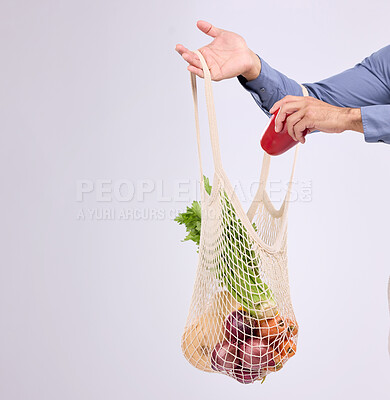 Buy stock photo Hand, shopping and bag for vegetables closeup in studio by background for diet, health or deal in recycle material. Grocery discount, fruit or vegetable for man, healthy food or sustainable lifestyle