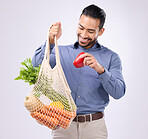 Healthy, happy and an Asian man grocery shopping with a bag isolated on a white background in a studio. Smile, choice and a Japanese male with food from a supermarket for a diet and nutrition