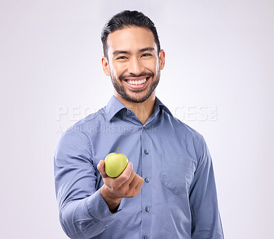 Buy stock photo Apple, studio portrait and man happy with product for weight loss diet, healthcare lifestyle or body detox. Wellness food, nutritionist person and male vegan giving fruit isolated on gray background