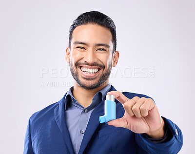 Buy stock photo Asthma, pump and portrait with a man in studio on a gray background holding a respiratory device for breathing. Happy, smile and a handsome young male with an inhaler to relieve coughing or wheezing