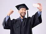 Man, graduate and selfie with smile for scholarship, profile picture or social media against a gray studio background. Happy excited male academic smiling for graduation photo, memory or online post