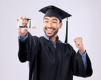 Asian man, selfie and smile for graduation, scholarship or diploma against a white studio background. Happy male graduate smiling for profile picture, vlog or photo in memory of milestone achievement