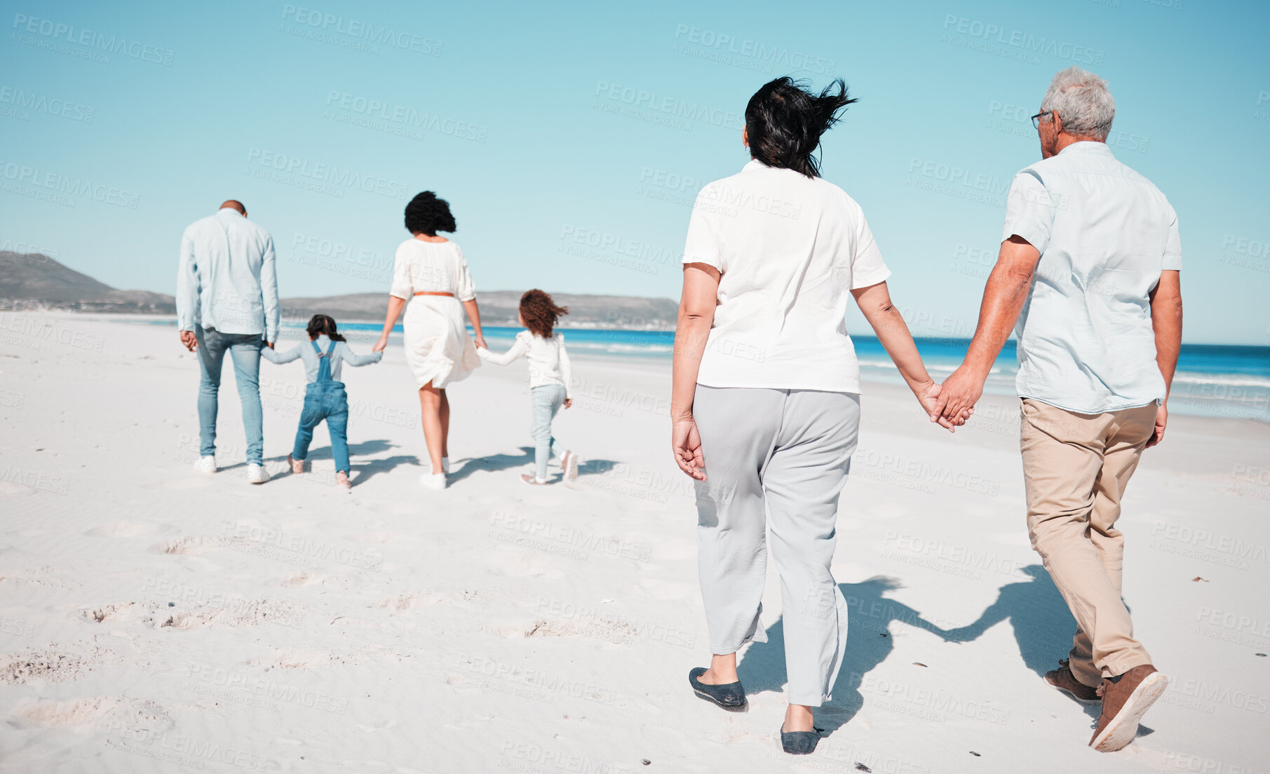 Buy stock photo Senior couple, holding hands and family at beach with back for walk, freedom and vacation together with love. Old man, woman and grandchildren by ocean for walking, wellness and adventure in sunshine