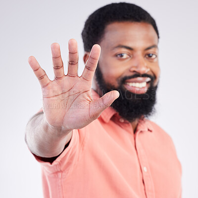 Buy stock photo Black man, hand sign and stop in studio portrait with smile, icon and communication by background. Young african model, signal or symbol for opinion, protest palm and warning with confident choice