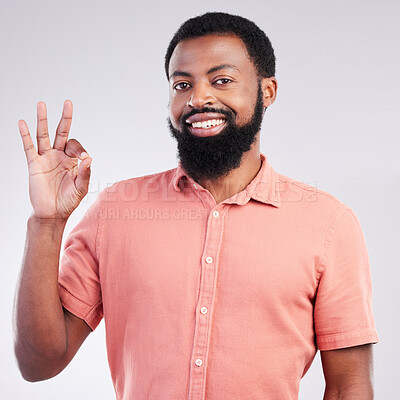 Buy stock photo Portrait, perfect and hand gesture with a black man in studio on a gray background to say magnifique. Emoji, communication and okay with a happy or handsome young male speaking in sign language