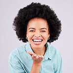 Happy, laughing and portrait of a black woman blowing kiss isolated on a white background in a studio. Laugh, smile and cheerful and beautiful African girl with a gesture for love, care and flirty