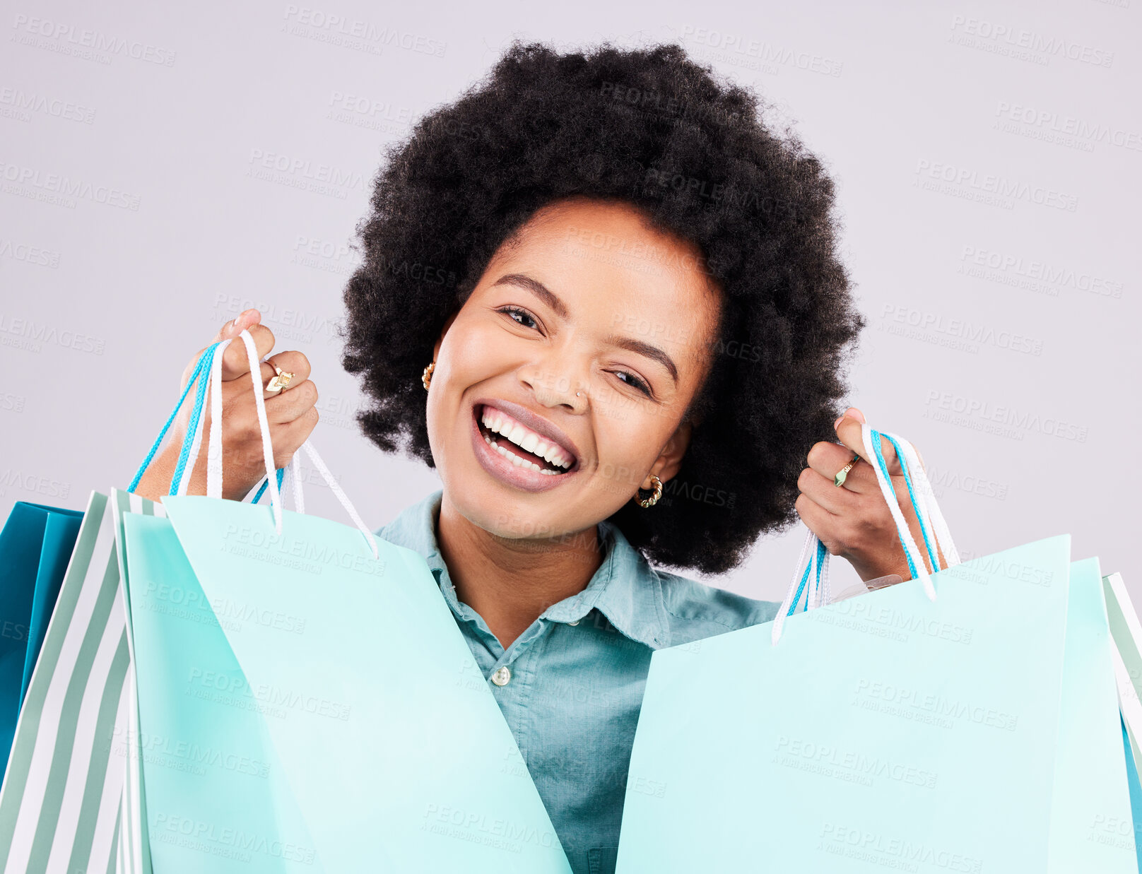 Buy stock photo Shopping bag, studio portrait and happy black woman with luxury sales product, designer fashion deal or mall store present. Commerce market, discount gift and retail customer face on gray background
