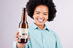 Hand, beer and advertising with a black woman in studio on a gray background for alcohol promotion. Portrait, bottle and beverage with a female holding a product for celebration or congratulations
