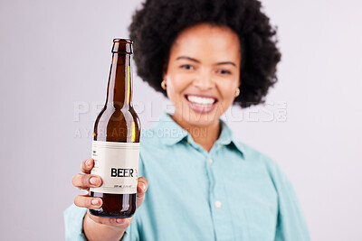 Buy stock photo Hand, beer and advertising with a black woman in studio on a gray background for alcohol promotion. Portrait, bottle and beverage with a female holding a product for celebration or congratulations