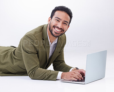 Buy stock photo Happy, laptop and portrait of a man in studio relaxing while typing on a keyboard doing research. Happiness, smile and Indian male model with computer working on project isolated by white background.