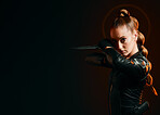 Woman, warrior and knife in studio with space for action, fight and safety from danger. Strong female model, assassin or agent in scifi leather cosplay costume with weapon on a dark mockup background