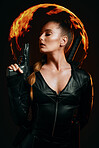 Woman, warrior and vigilante in cosplay with gun ready for battle, war or game against a dark studio background. Female in black widow costume with guns and sword for halloween or hunger games