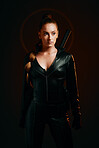 Woman, warrior and fashion outfit in studio for action, fight and safety from danger in a dark studio. Strong female model, assassin or killer in scifi leather cosplay costume with weapon for action