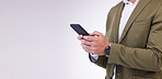 Businessman, hands and phone typing on mockup for social media or communication against a gray studio background. Hand of isolated employee man texting, chatting or browsing on mobile smartphone app
