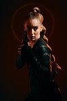 Woman, warrior and fist to fight in studio for action and safety from danger on dark background. Strong female model, assassin or agent in scifi cosplay costume with weapon for action and defense