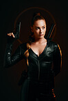 Serious woman, warrior and gun in studio for action, fight and safety from danger on dark background. Strong female assassin or agent in scifi leather cosplay costume with weapon to fight or guard
