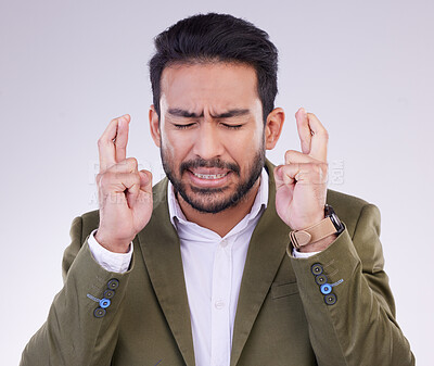 Buy stock photo Success, business and Asian man with fingers crossed, hope and promotion against a studio background. Japanese male employee, entrepreneur and guy with luck, opportunity and hand emoji sign for prize