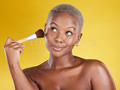 Buy stock photo Face, makeup and beauty of black woman with brush in studio isolated on a yellow background. Thinking, cosmetics and happy African female model with tool to apply foundation or powder for facial skin