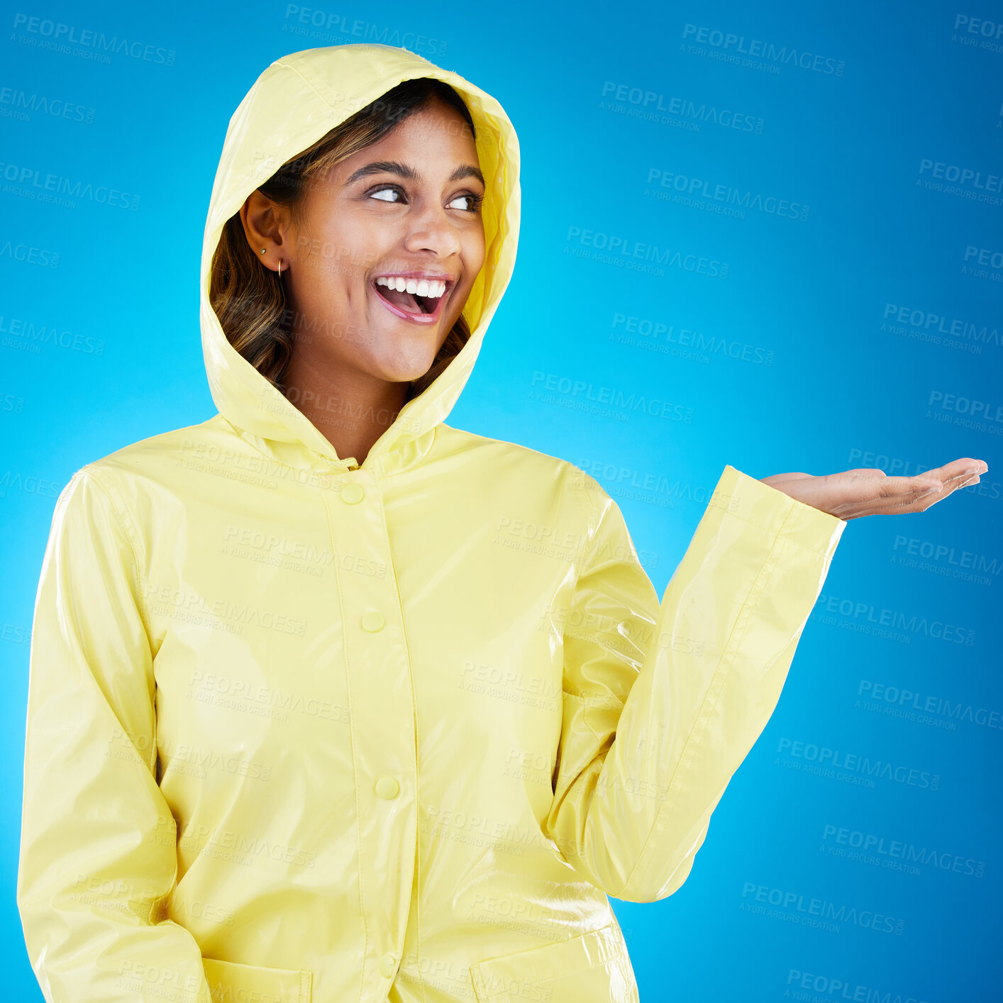 Buy stock photo Hand, rain and happy woman in studio excited for weather, drop or storm while posing on gradient blue background. Smile feeling and girl enjoy rainfall, splash and winter season, cheerful or isolated