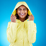 Cover, happy and portrait of a woman with a raincoat isolated on a blue background in a studio. Smile, laughing and girl wearing a jacket to protect from rain, the cold or bad weather on a backdrop