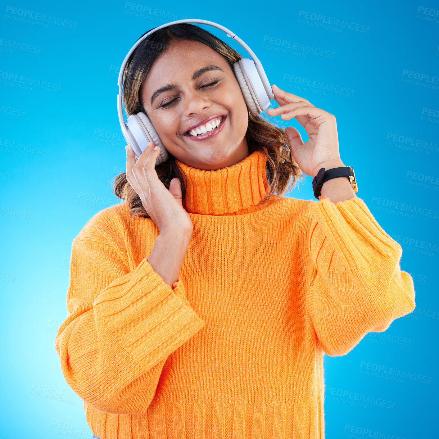 Buy stock photo Music headphones, smile and woman in studio isolated on a blue background. Podcast, radio and happy Indian female with eyes closed streaming, listening and enjoying sound, audio or song with headset.