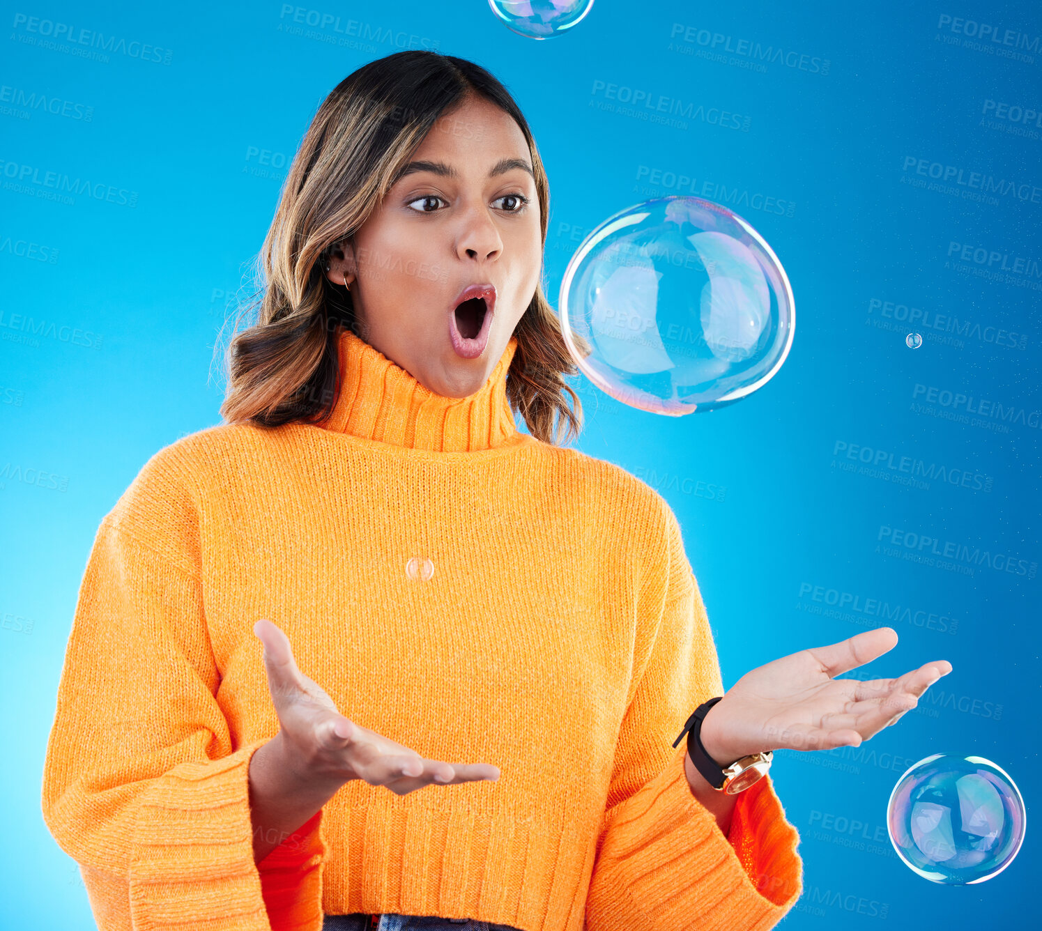 Buy stock photo Surprise, shock and bubble with indian woman in studio for soap, positive and satisfaction. Magic, creative and holding with female isolated on blue background for bright, cute and entertainment