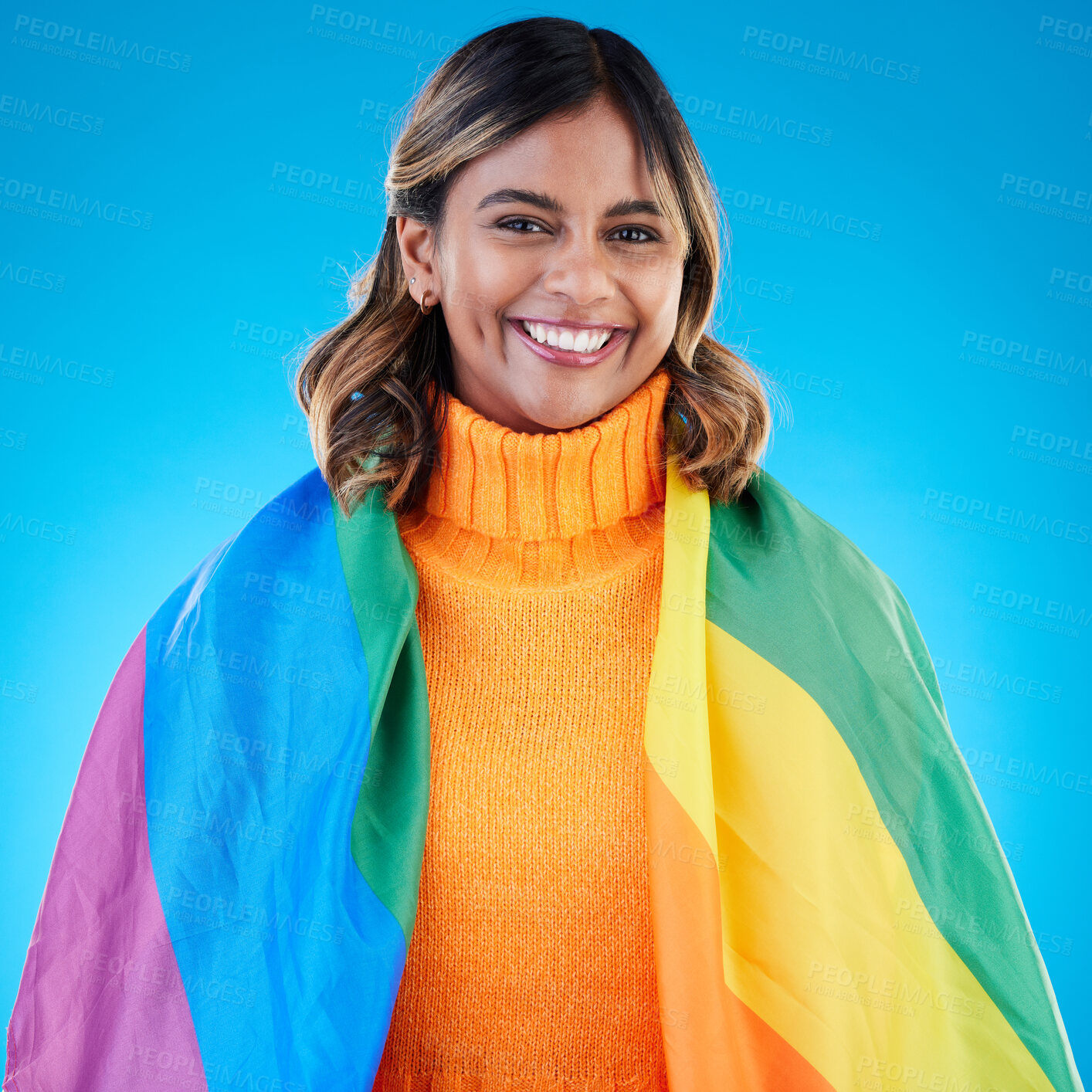 Buy stock photo Portrait, pride and woman with rainbow flag, queer and acceptance against a blue studio background. Face, female and happy girl with symbol for lgbtq community, equality and transgender with support