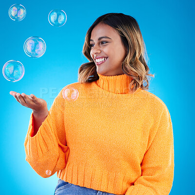 Buy stock photo Happy, holding and bubble with indian woman in studio for soap, positive and satisfaction. Magic, creative and smile with female isolated on blue background for bright, cute and entertainment