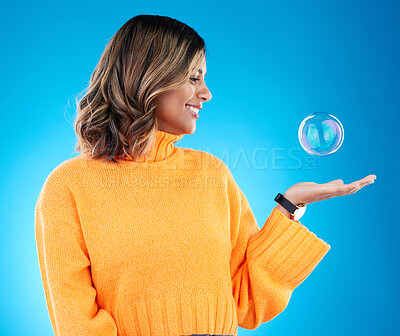 Buy stock photo Happy, smile and bubble with indian woman in studio for soap, positive and satisfaction. Magic, creative and holding with female isolated on blue background for bright, cute and entertainment