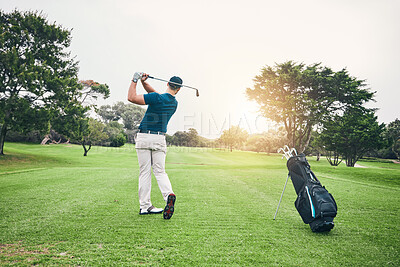Golf, stroke and training with a sports man swinging a club on a field or course for recreation and fun. Golfing, grass and hobby with a male golfer playing a game on a course during summer