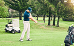 Golf, stroke and hobby with a sports man swinging a club on a field or course for recreation and fun. Golfing, grass and training with a male golfer playing a game on a course during summer