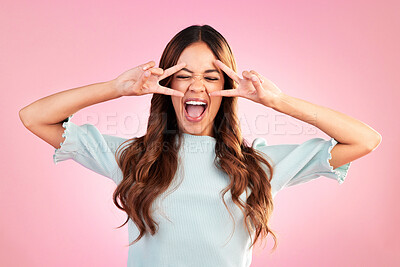 Buy stock photo Peace sign, screaming and funny woman in studio isolated on a pink background. Hand gesture, shouting and crazy, beauty and happy mixed race female model with v symbol for comic expression or emoji.