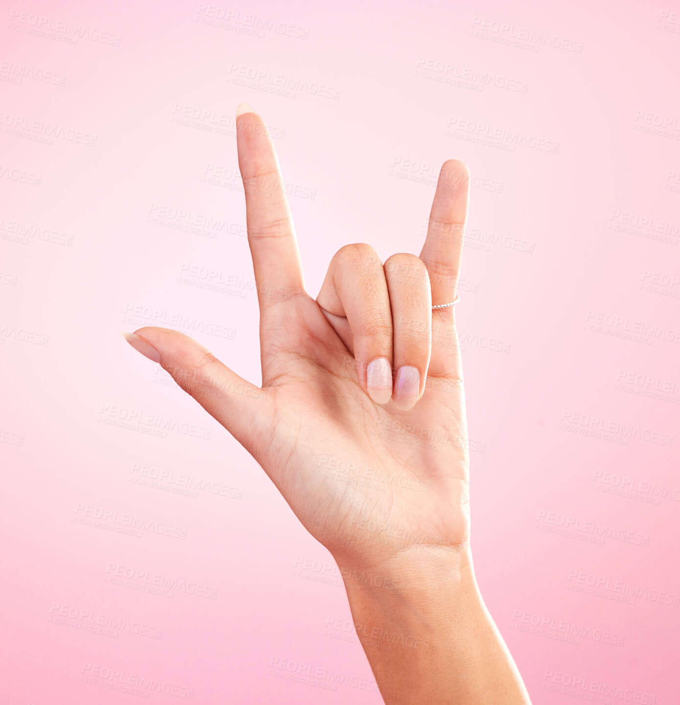Buy stock photo Hands, closeup and woman in studio with rock and roll sign, gesture or symbol against pink background. Zoom, rebel and girl with rocker emoji for edgy, cool or contemporary, metal or punk aesthetic 