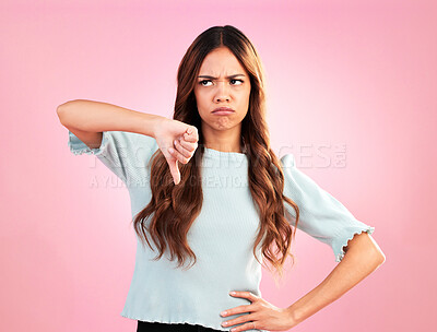 Buy stock photo Sad, hands and thumbs down by woman in studio for bad review, complaint or disappointed on pink background. Frown, finger and emoji expression by girl with vote for wrong, bad news or reject isolated