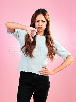 Buy stock photo Portrait, thumbs down and hands of sad woman in studio for bad review, complaint or disappointed on pink background. Face, finger and emoji expression by girl with vote for wrong, bad news or reject