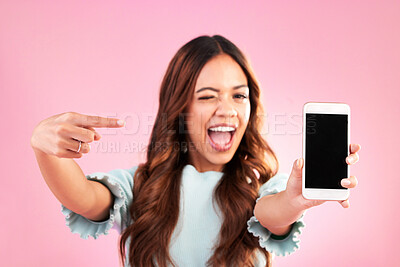Buy stock photo Phone screen, wink and woman pointing to mockup in studio isolated on pink background. Cellphone, face portrait or happy female with mobile smartphone for advertising, marketing or product placement.