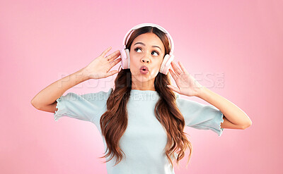 Buy stock photo Music headphones, singing and woman whistle in studio isolated on a pink background. Singer, thinking and mixed race female streaming, enjoying and listening to audio, sound track or radio podcast.