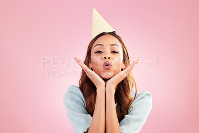 Buy stock photo Birthday woman, face portrait and kiss for celebration event, congratulations or celebrate studio happiness. Emoji gesture, party hat and headshot female, person or young model on pink background