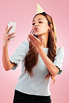Selfie, birthday party and kiss of woman in studio isolated on a pink background. Air kissing, profile picture and mixed race female taking photo for happy memory, social media or special celebration