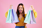 Woman excited about shopping purchase, paper bag and retail, happy in portrait on pink background. Cheers, excitement about discount and promotion, fashion product and female with smile in studio 