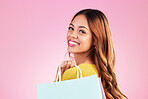 Portrait, retail and smile with a black woman customer in studio on a pink background for shopping. Face, fashion or sale and an attractive young female shopper happy with a deal or promotion