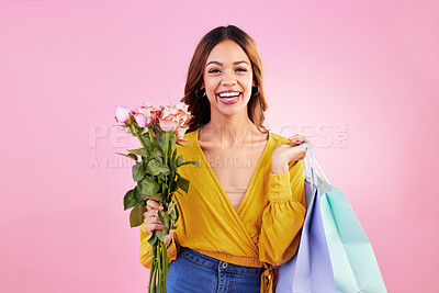 Buy stock photo Happy, shopping bags and flowers with portrait of woman in studio for retail, birthday and spring. Event, party and smile with female and roses on pink background for sale, discount and romance