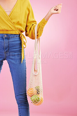 Buy stock photo Hand, shopping bag and fruits for woman in studio by pink background for diet, health or deal in recycle material. Grocery discount, fruit or healthy food with produce, sustainability and lifestyle