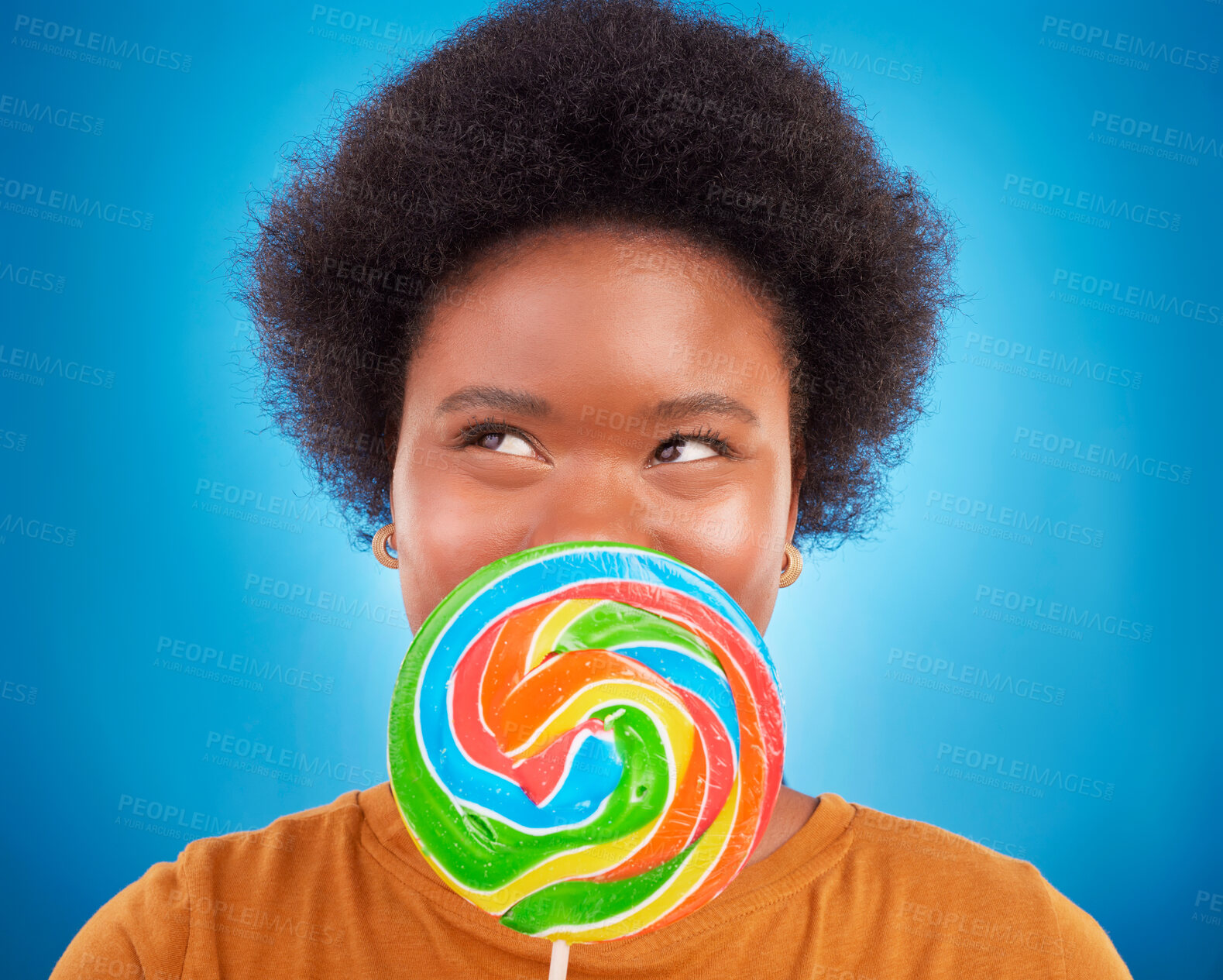 Buy stock photo Sweet, happiness and black woman with lollipop, excited and lady on blue studio background. African American female, candy and girl with dessert, happy and cheerful with joy, treat and confectionary