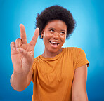 Peace sign closeup, black woman hand and African model with a smile and happiness. Isolated, blue background and v hands gesture of a happy young female with a afro and beauty feeling excited