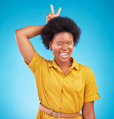 Buy stock photo Silly, peace sign and woman in a studio feeling fun, playful and funny with a blue background. V hand gesture, bunny ears and tongue out for comedy with a young female model smile with happiness 