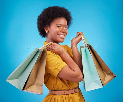 Buy stock photo Happy black woman, shopping bag and portrait on blue background, studio and product sales. Customer, female model and smile with gift bags, retail discount promotion or luxury brand offer to consumer